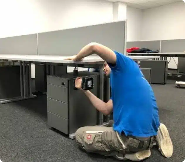 Monteur bei der fachgerechten Montage von Büromöbeln in einem modernen Büro