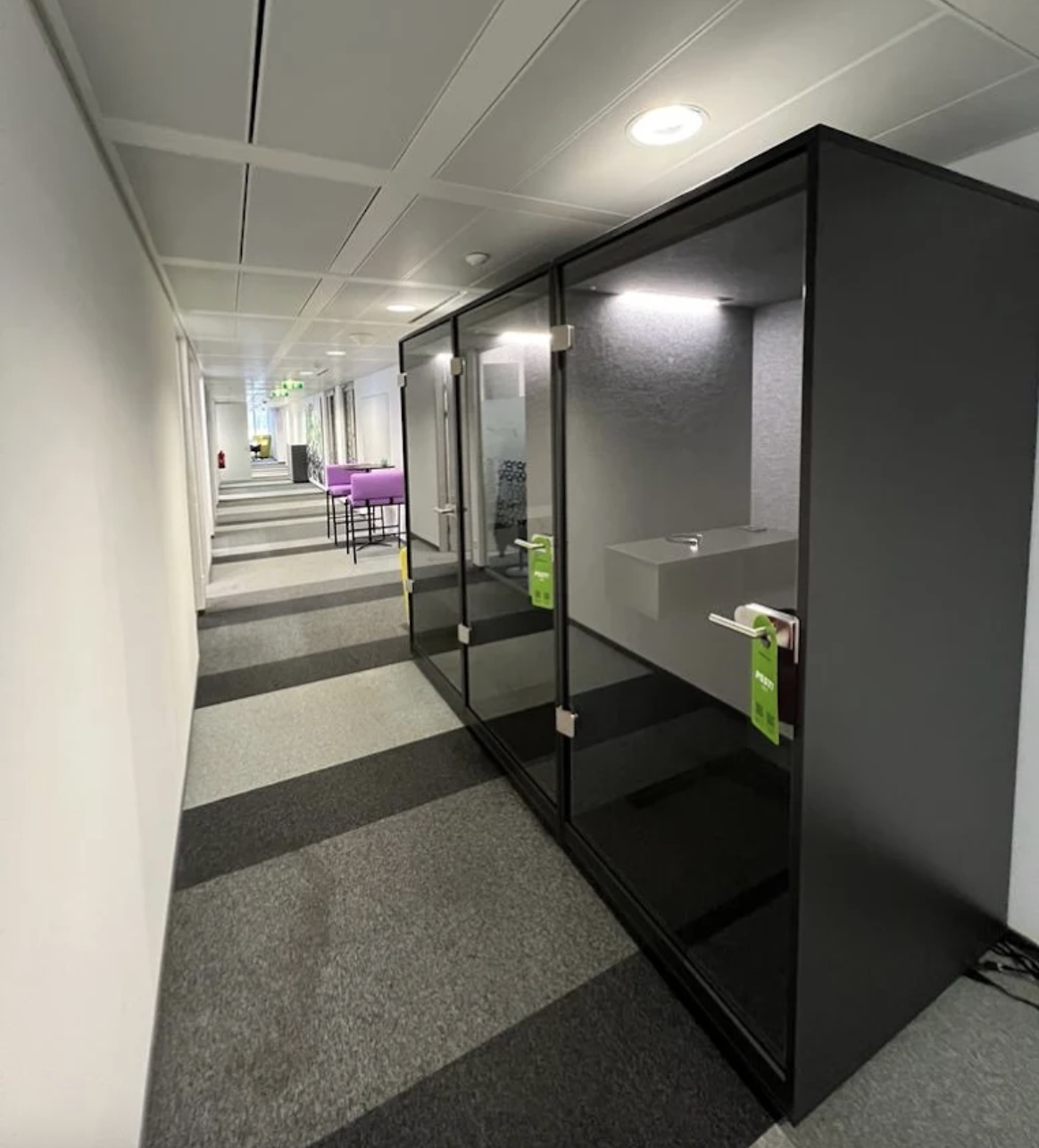 Moderne Büroflur mit schallisolierten Telefon- und Besprechungskabinen aus Glas