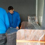 Möbelmonteur-Team verlädt sorgfältig Möbel im Transporter während eines Umzugs in Wien.