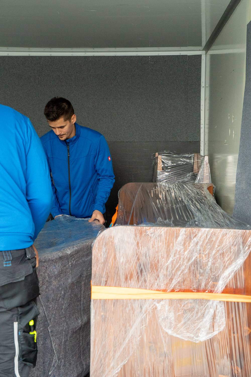 Möbelmonteur-Team verlädt sorgfältig Möbel im Transporter während eines Umzugs in Wien.