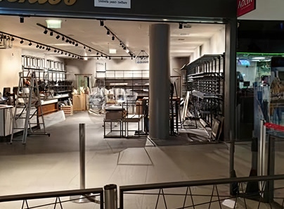 Abschlussarbeiten bei der Geschäftseinrichtung, Montage von Regalen und Beleuchtung in einem modernen Verkaufsraum