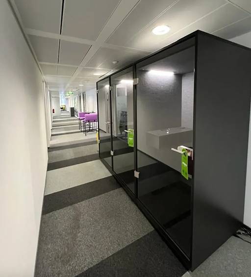 Moderne Büroflur mit schallisolierten Telefon- und Besprechungskabinen aus Glas